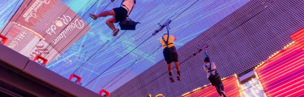 People riding the SlotZilla Zip Line on Fremont Street in Las Vegas Nevada.