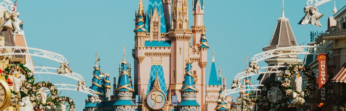 A crowd of people in front of Castle in Disney World Florida.