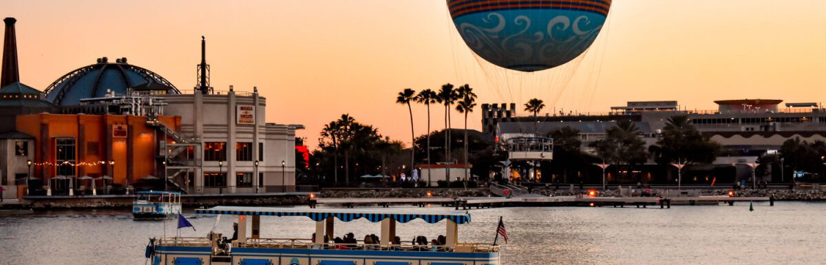 Panoramic view of Disney Springs and water taxi on colorful sunset background at Lake Buena Vista area in Orlando, Florida, USA.