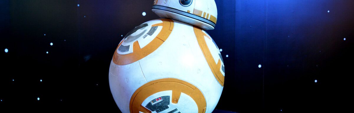 BB-8 android model on a black table with black and blue light background.