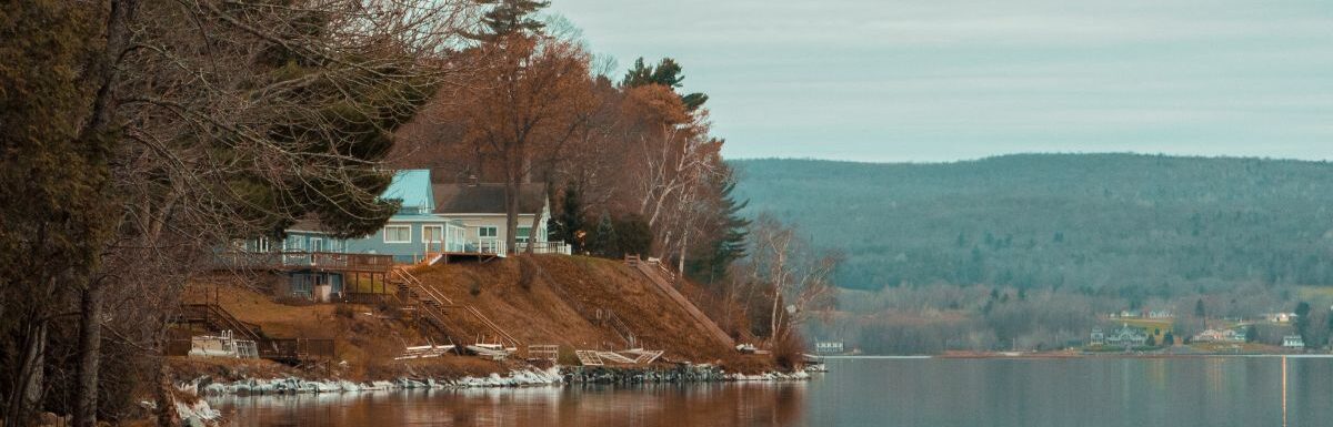 Lakeside view with a house nearby.