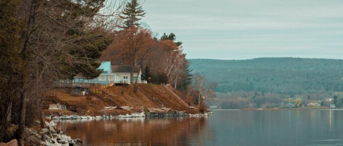 Lakeside view with a house nearby.