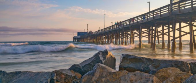 Beautiful golden hour with colorful scattered clouds as the sun sets over Balboa Pier on Newport Beach in California USA near Anaheim.