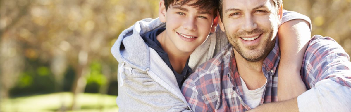 Portrait of father and son in countryside.