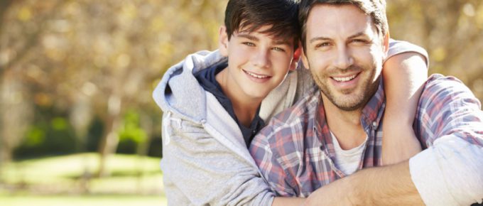 Portrait of father and son in countryside.