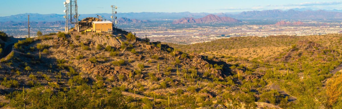Tranquil sunset mountain landscape with brown bench and communication towers at South Mountain Park in Phoenix, Arizona, USA.