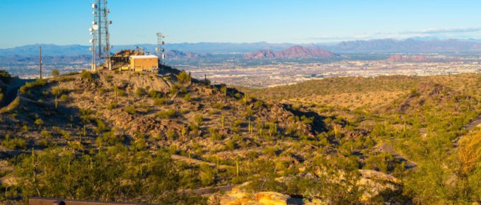 Tranquil sunset mountain landscape with brown bench and communication towers at South Mountain Park in Phoenix, Arizona, USA.