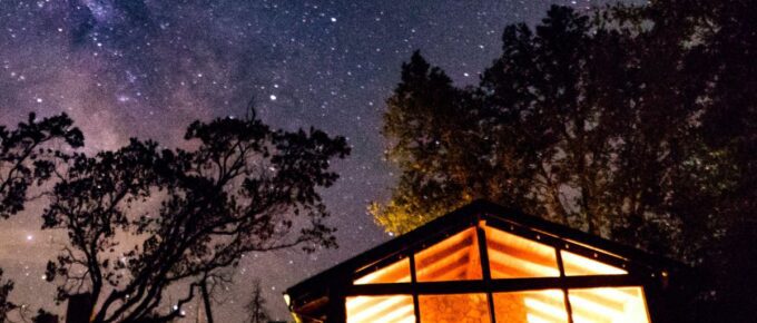 Silhouette of a cabin near trees during nighttime.
