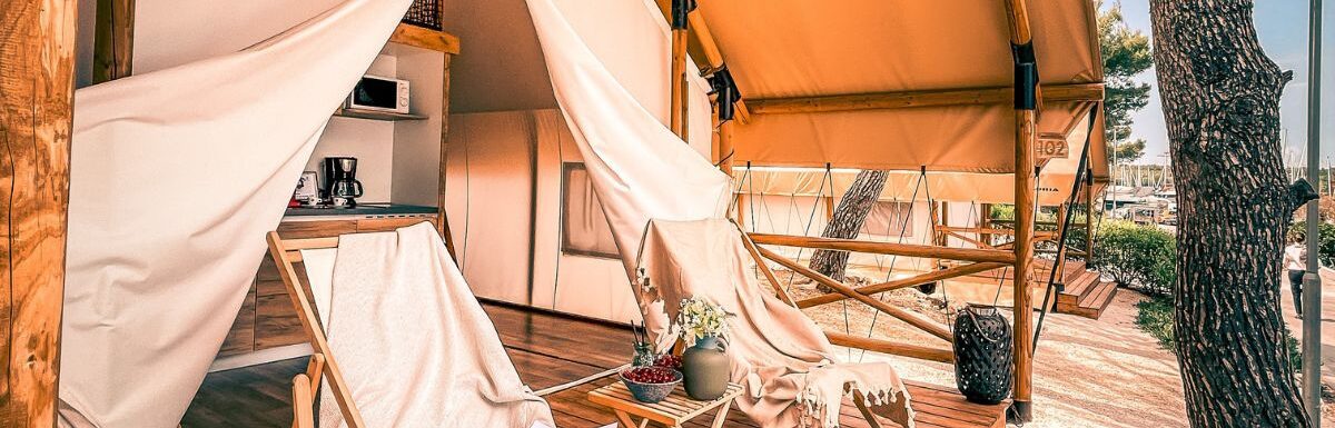 White and brown patio umbrella with chairs that can also be used for glamping.
