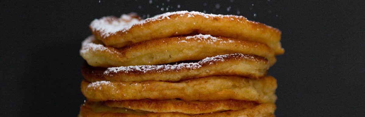 Pile of pancakes on black background.