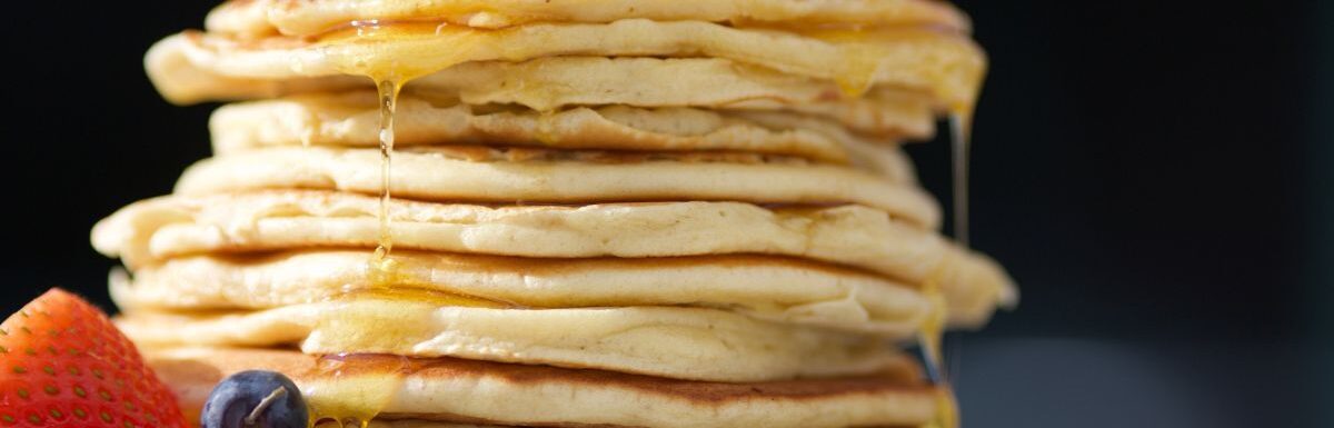 Pile of pancakes on a white plate.