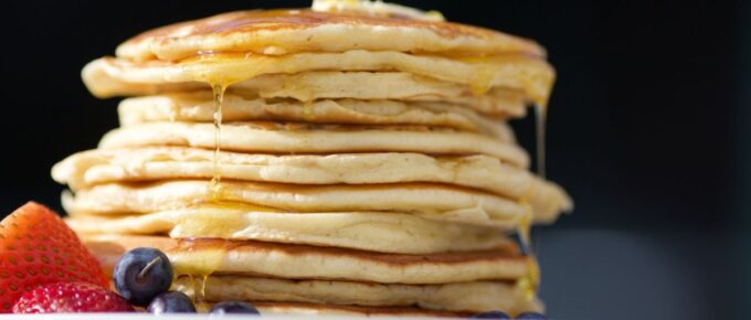 Pile of pancakes on a white plate.
