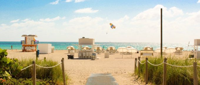 Gray pathway leading to parasol and lifeguard house in South Beach, Miami Beach, United States.
