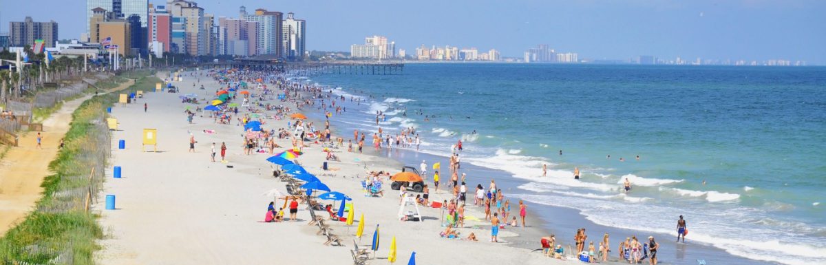 View of Myrtle Beach in South Carolina with a lot of people under colorful umbrellas.