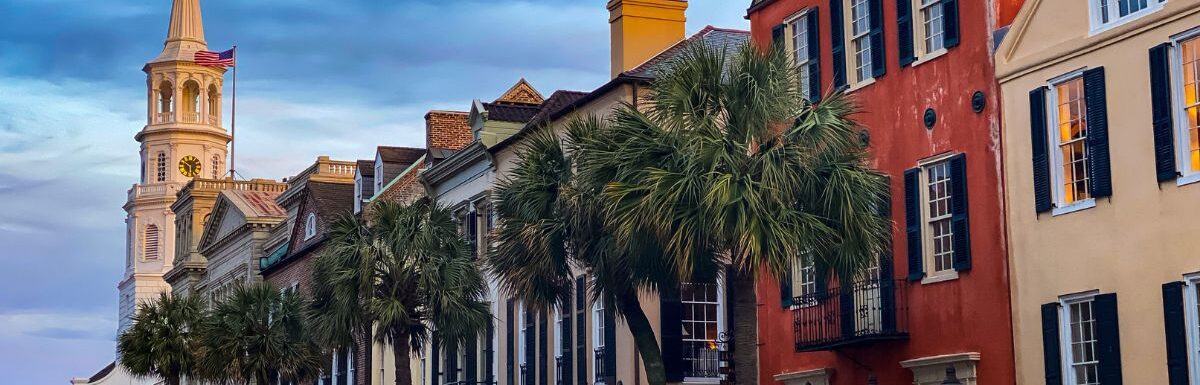 Cars parked beside brown concrete building during daytime in Charleston, South Carolina, USA.