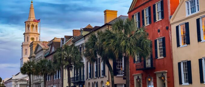 Cars parked beside brown concrete building during daytime in Charleston, South Carolina, USA.