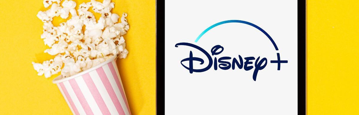 opcorn bucket and tablet with Disney plus logo on yellow background.