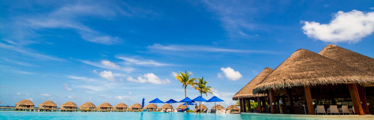 Infinite pool with water villas in the background.