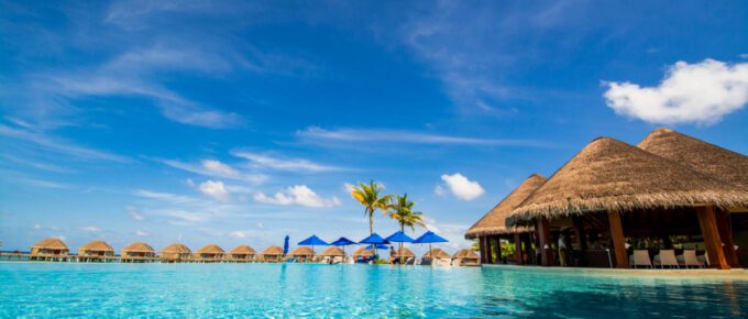 Infinite pool with water villas in the background.