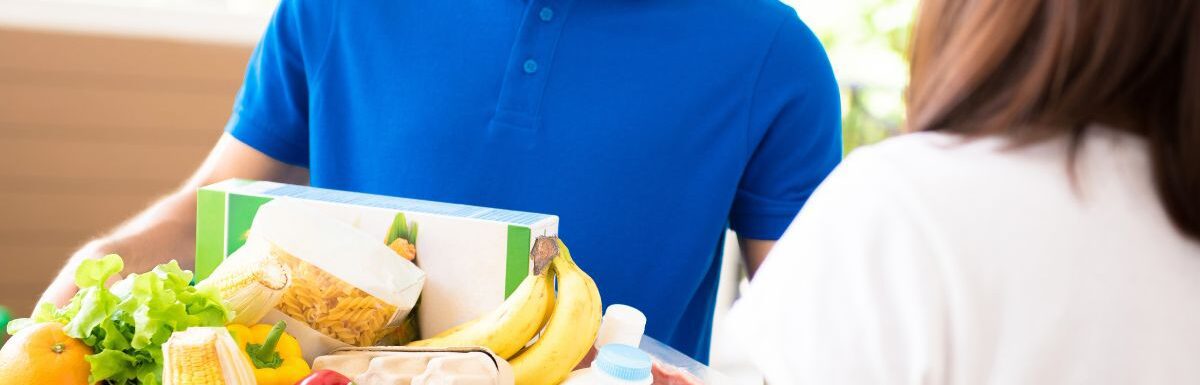 Delivery man delivering food to a woman at her place.