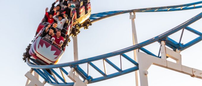 People ride roller coasters during the daytime.