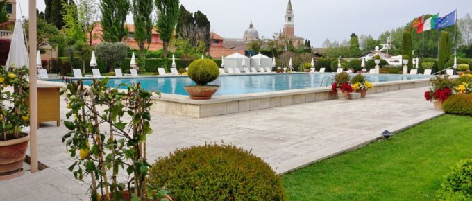 Pool area with green plants and grass around in the Belmond Hotel Cipriani, on the Giudecca in Venice, is one of the most expensive hotels in the world.