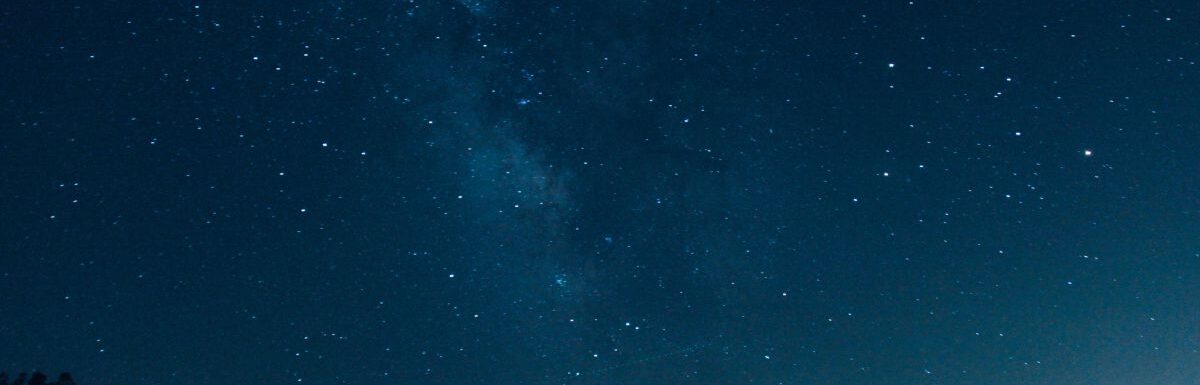 Silhouette of two people watching the stars at night.