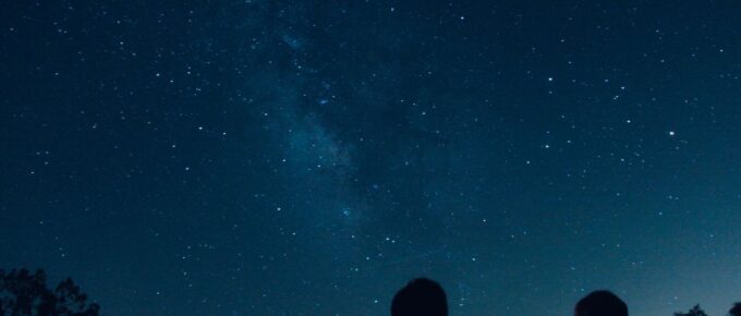 Silhouette of two people watching the stars at night.