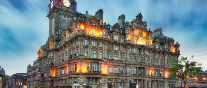 Edinburgh at night scene with Lights on Princess street and Balmoral hotel on background.
