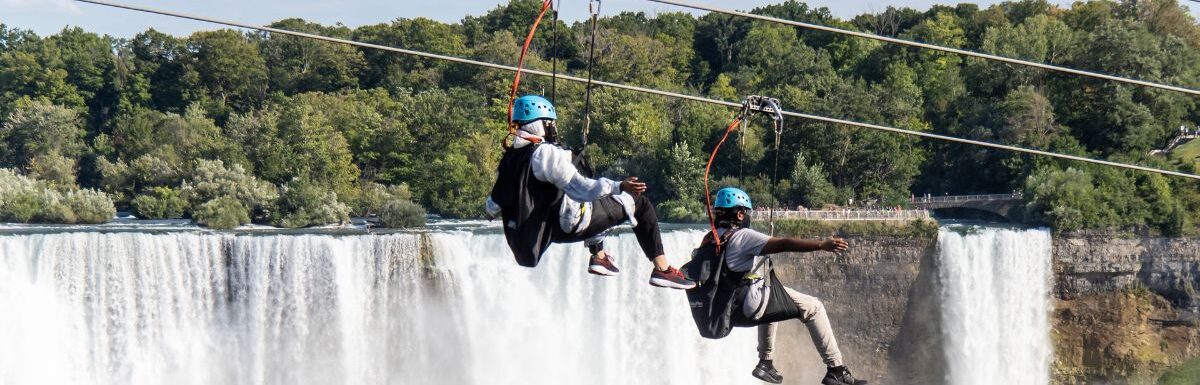 Zip lining tourists pass by the American Falls on their way to the bottom of the gorge of the Niagara River.