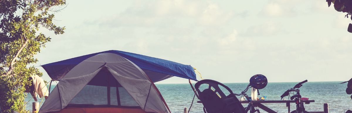 Tent on the beach with bicycles on the side on a sunny day.